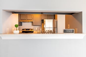 A kitchen with a white shelf displaying a sign that says at BellaVista Apartments in Woodbridge, VA
